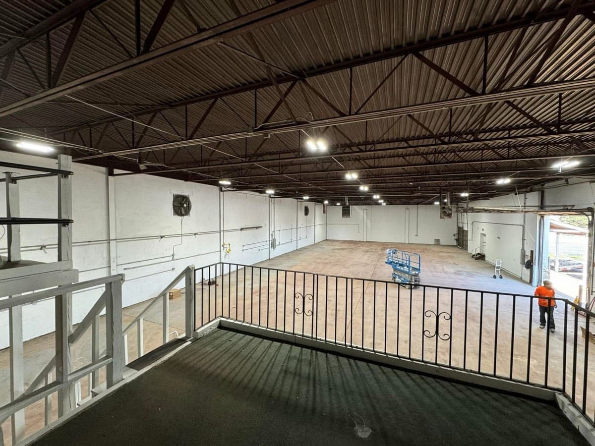 A warehouse interior lit by new high bay fixtures, seen from the mezzanine